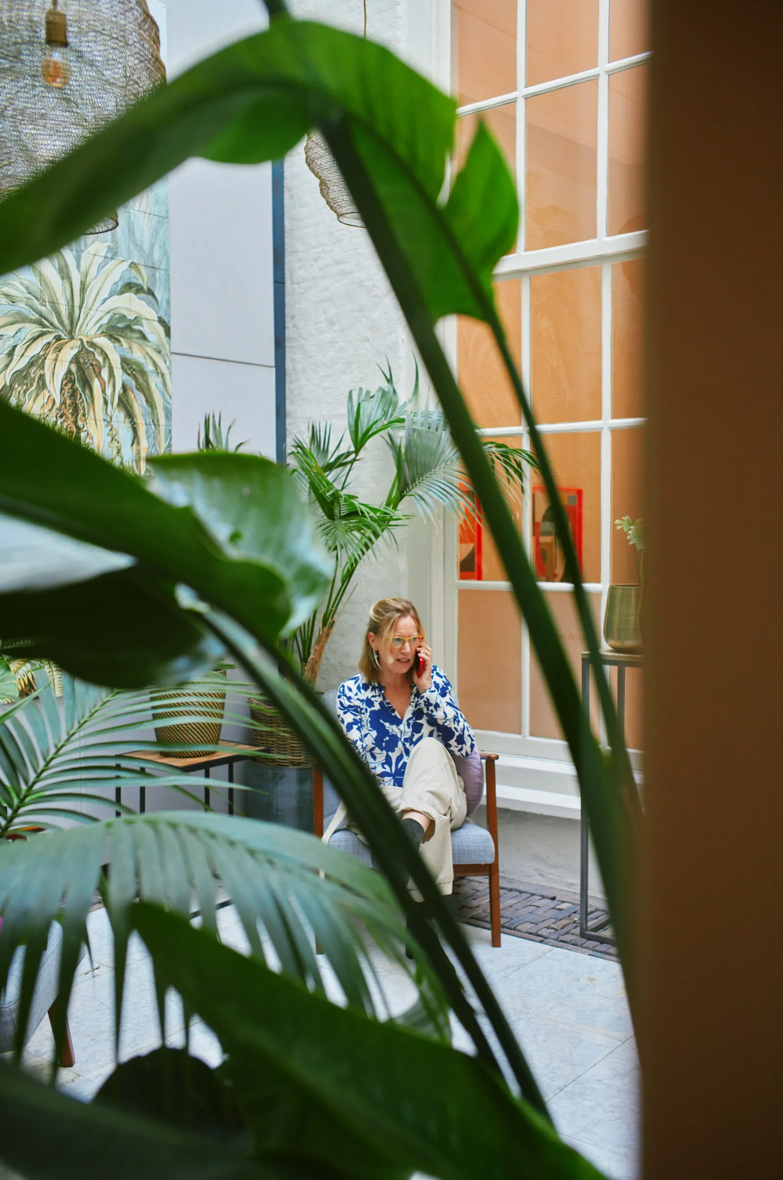 Collega aan het bellen omgeven door planten